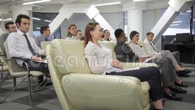 年轻的专业人士在大型公司室内的每周会议上。